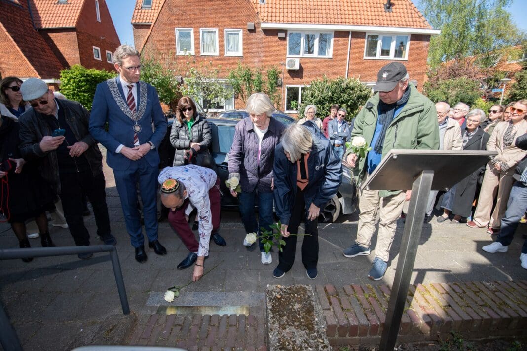 069 22042026 Burgemeester Tjapko Poppens en leden van de werkgroep Randwijcklaan 13 leggen rozen bij de stolperdrempel 2